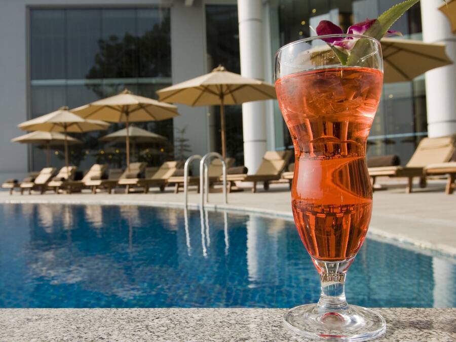 Alberca al aire libre, sombrillas en la alberca y camastros