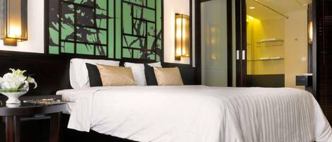 A hotel room with a bed, bedside table, and a wall with a geometric pattern.