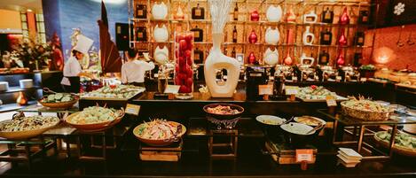 A buffet with various dishes and a display of plates.