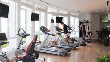 A gym with treadmills, stationary bikes, and weight machines.