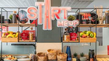 Una barra de desayuno con un letrero que dice "START ME UP" y diversas opciones de comida y condimentos.