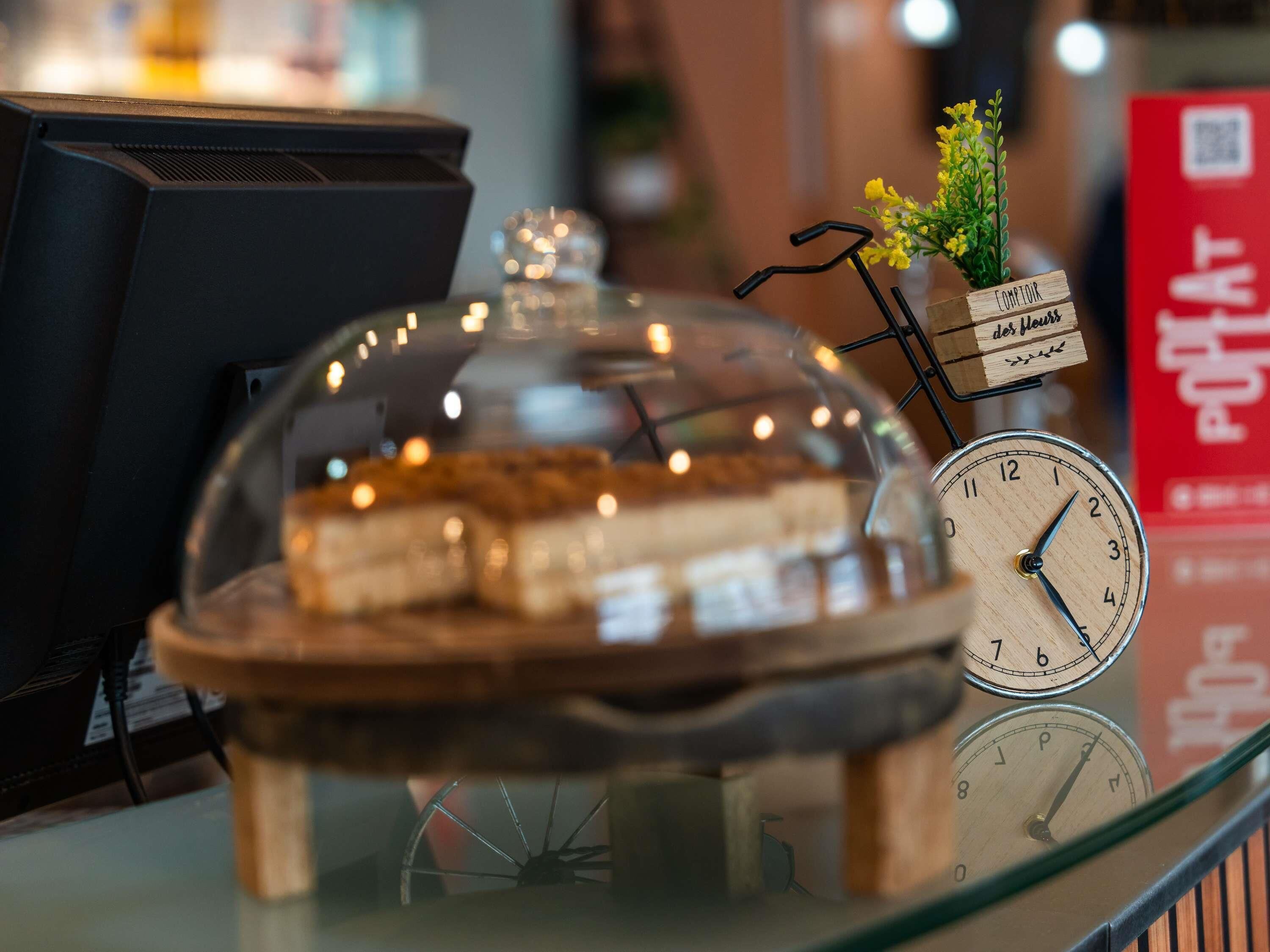 A dessert display with a clock and a sign reading 'COMFORT der Meinf.'