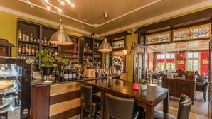 A bar area with a counter, stools, and shelves of bottles. - Hotel Bentheimer Hof (Bad Bentheim)