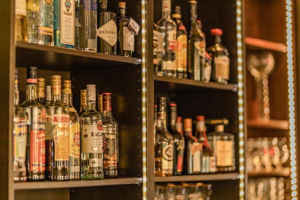 Shelves stocked with various liquor bottles, including brands like Hendrick's Gin and Bacardi.