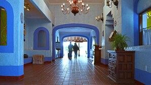 A hallway with blue walls, a chandelier, and a potted plant. - Villas Arqueologicas Teotihuacan (Teotihuacan)