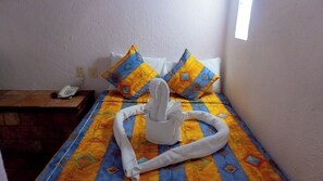 A hotel room with a bed, pillows, a telephone, and a window. - Villas Arqueologicas Teotihuacan (Teotihuacan)