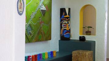 Una habitación con un mapa, una máscara colorida y una planta pequeña en un estante.