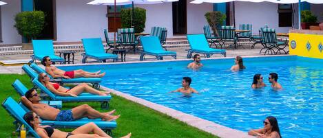 Un área de piscina con sillas de descanso y sombrillas.