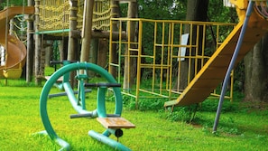 Une aire de jeux avec un toboggan, des structures d’escalade et des appareils de musculation.