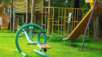 Un parque infantil con tobogán, estructuras para escalar y equipo de ejercicio.