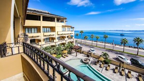 Un hotel con piscina, mobiliario exterior y vistas al mar.
