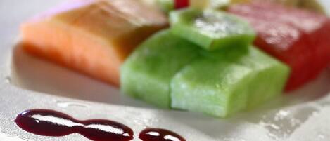 A plate with various food items including salmon, green vegetables, and a red sauce.