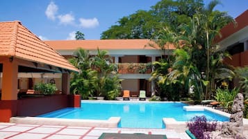 Alberca al aire libre, sombrillas en la alberca y camastros