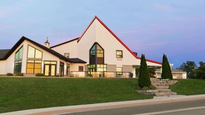A modern two-story building with a prominent red roof, large windows, and a well-maintained lawn. - Days Inn by Wyndham Kingston (Kingston)