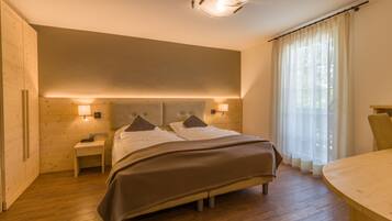 A bedroom with a bed, bedside tables, and a window with curtains.