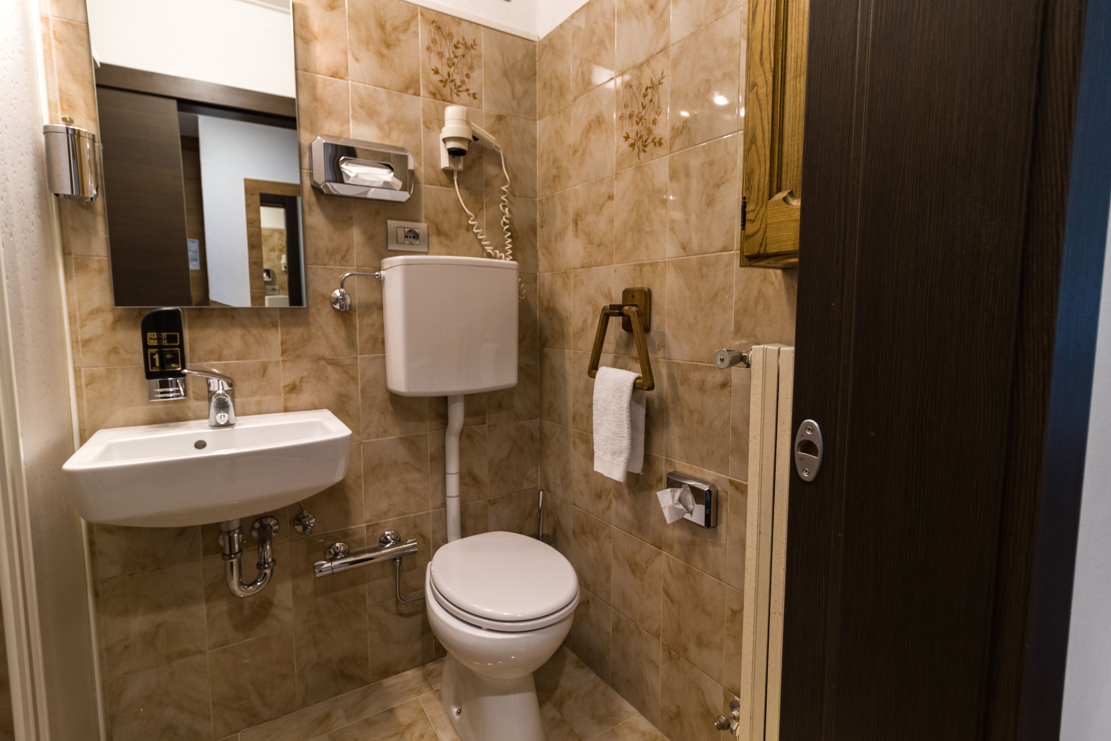 Une salle de bain avec un lavabo, des toilettes et un miroir.