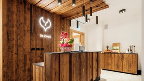 Ein Empfangstresen mit Holzoptik, ein leuchtendes Herzschild und eine Blumenkomposition.