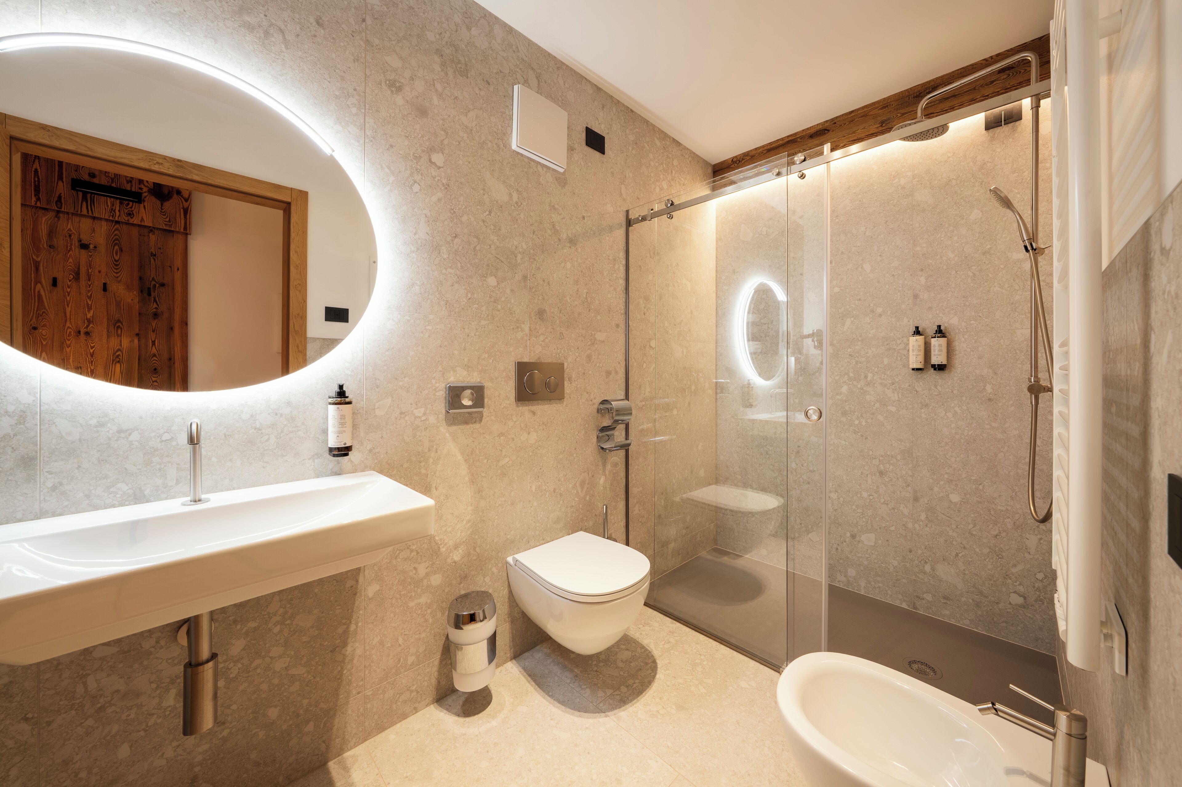 A modern bathroom with a sink, toilet, and shower.
