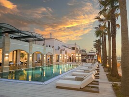 Una piscina techada, una piscina al aire libre de temporada, sombrillas