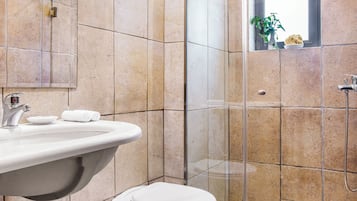 A bathroom with a sink, toilet, and shower.
