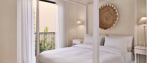 Una cama con dosel y ropa de cama blanca, dos mesitas de noche con lámparas y una obra de arte en la pared hecha con fibras naturales.