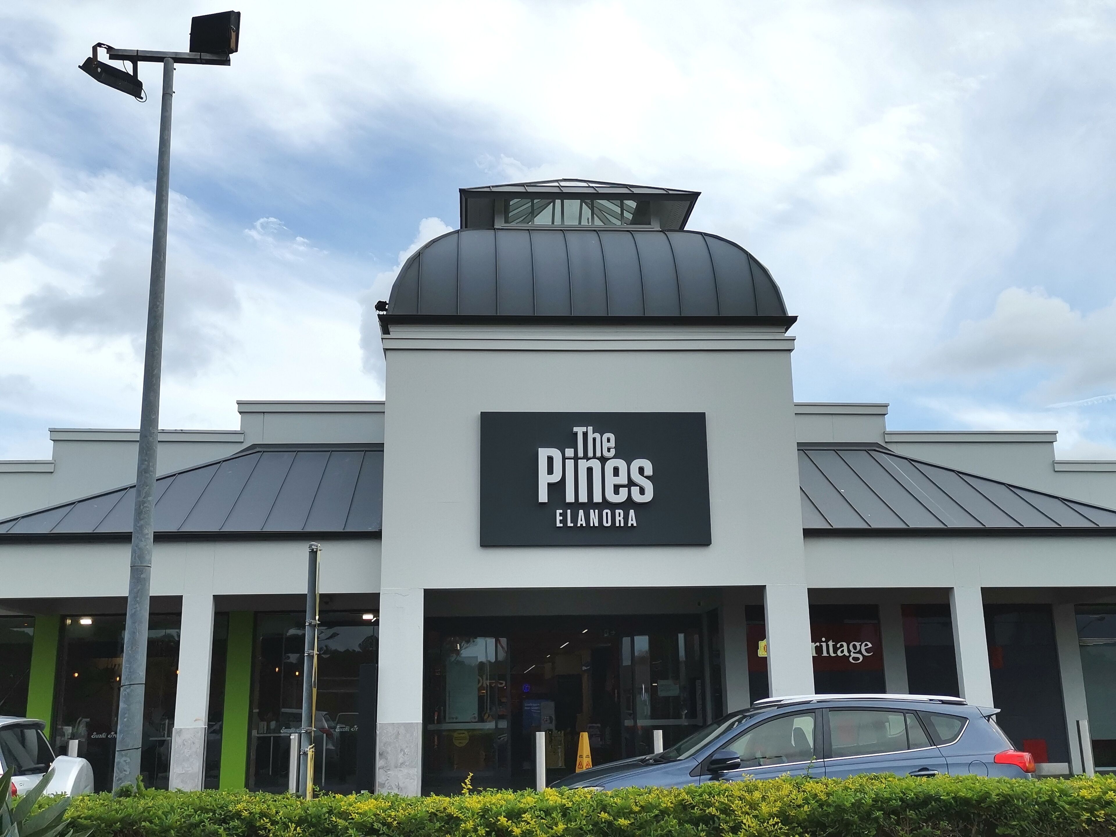 A building with a sign reading "The Pines Elanora."