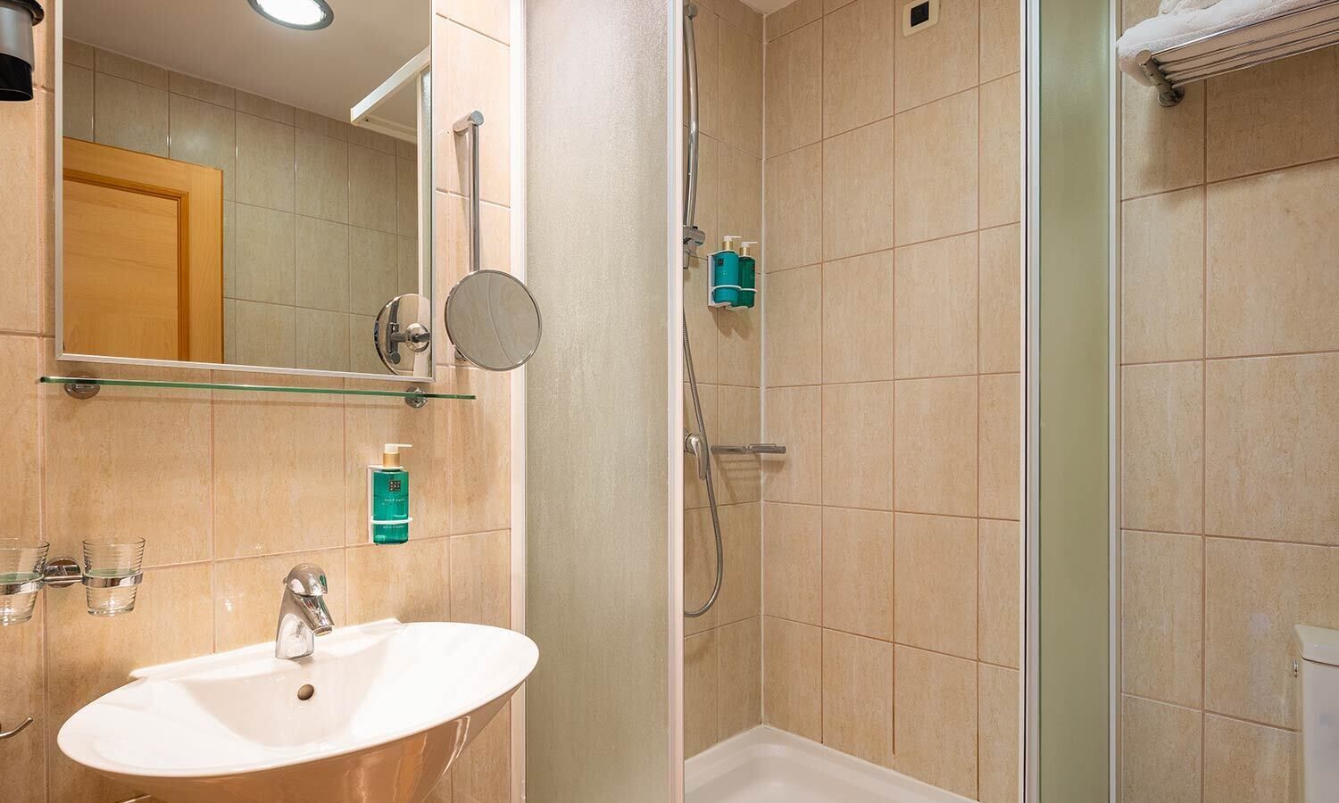 A modern bathroom with a sink, mirror, and shower.