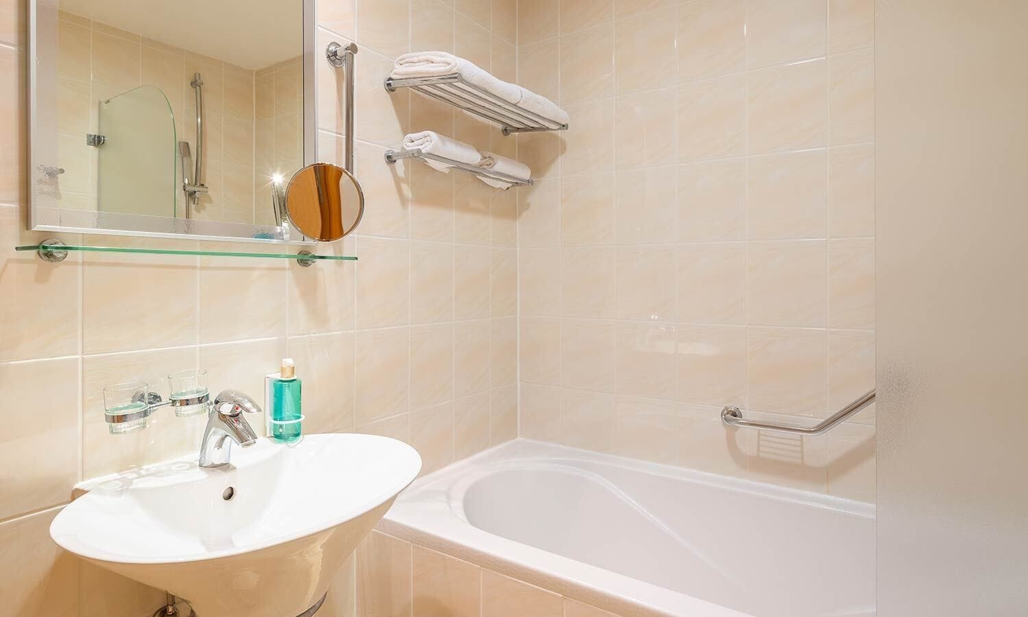 Une salle de bain avec un lavabo, un miroir et une baignoire.