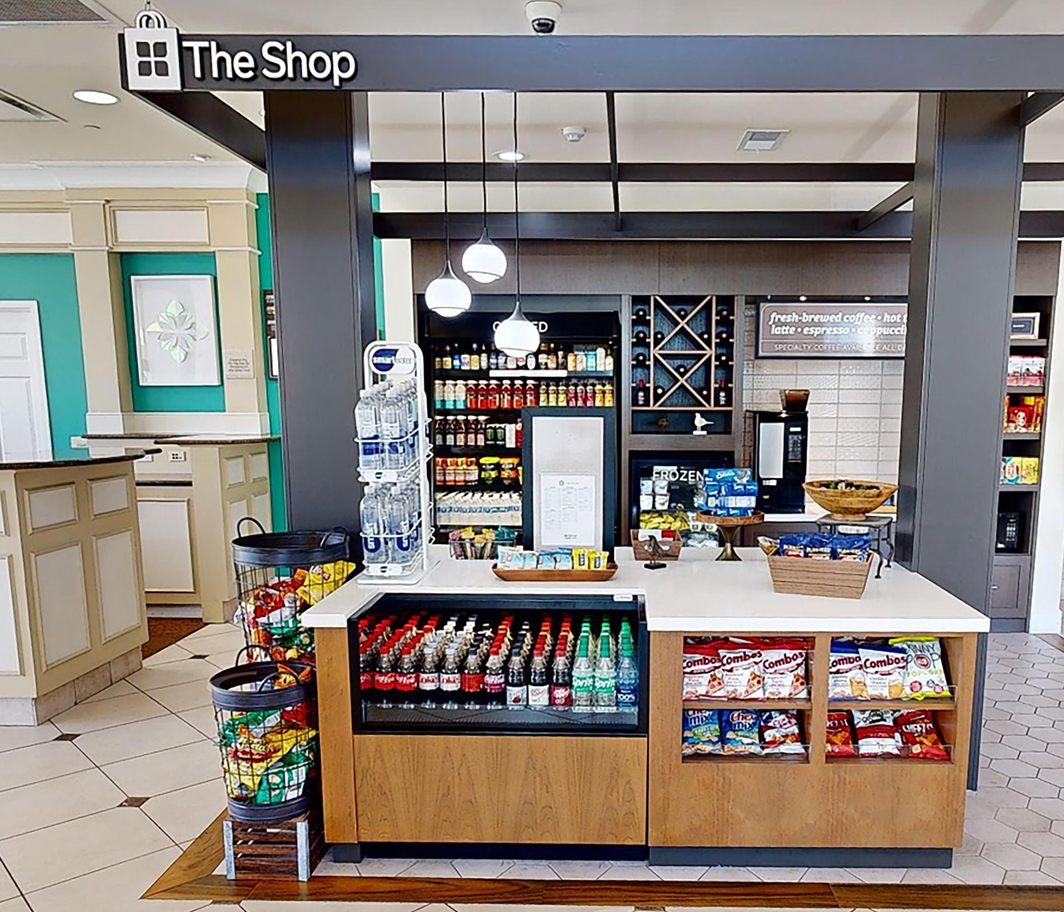 A coffee shop with a refrigerated display, a water dispenser, and a variety of snacks.