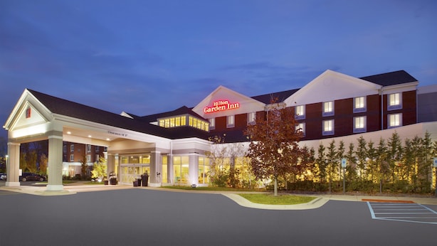 A hotel with a prominent 'Hilton Garden Inn' sign, a covered entrance, and a parking lot. - Hilton Garden Inn Detroit/Novi (Novi)