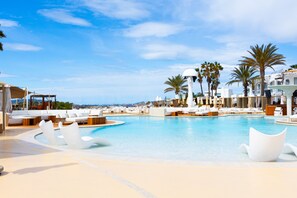 A resort pool with white lounge chairs and palm trees. - Destino Five Ibiza - 5-Star Grand Luxe Resort - Free Entrance to Pacha Club (Santa Eulalia del Rio)
