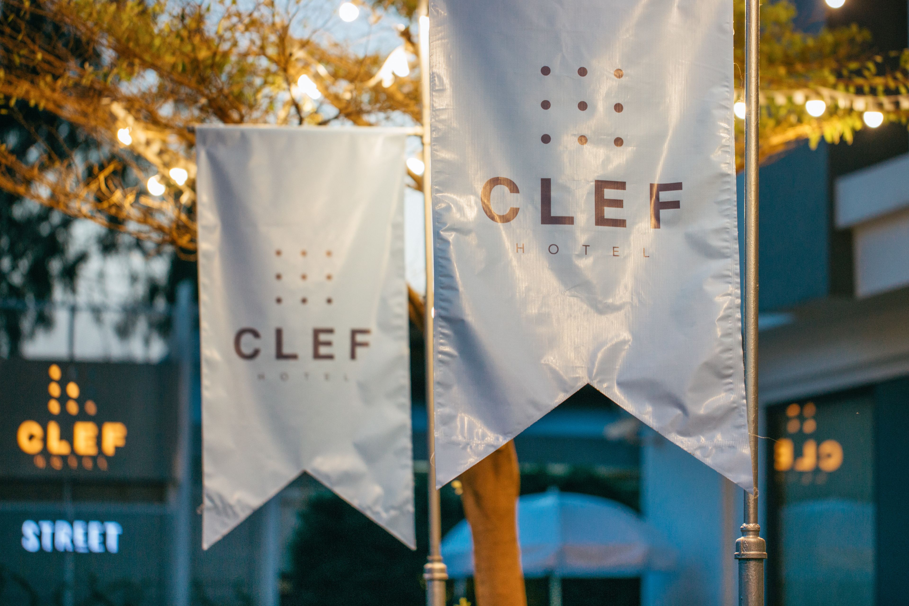 Two white banners with the text "CLEF HOTEL" hanging from a pole.