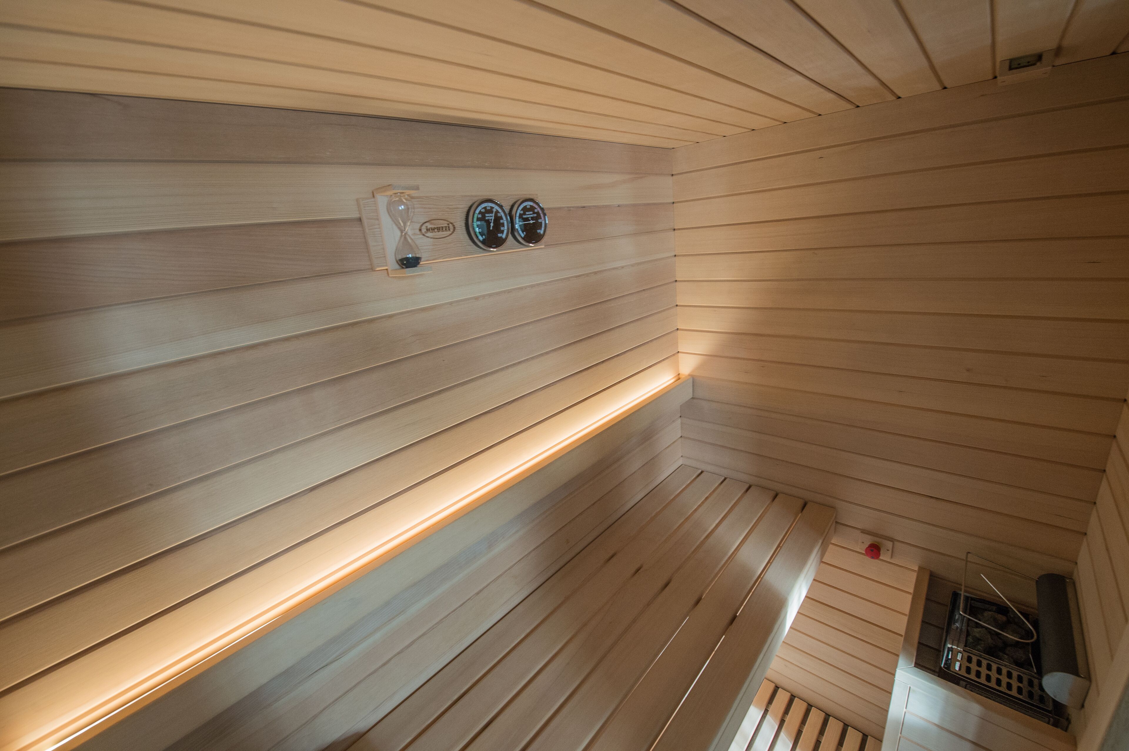 Un interior de madera con techo inclinado y estanterías empotradas.
