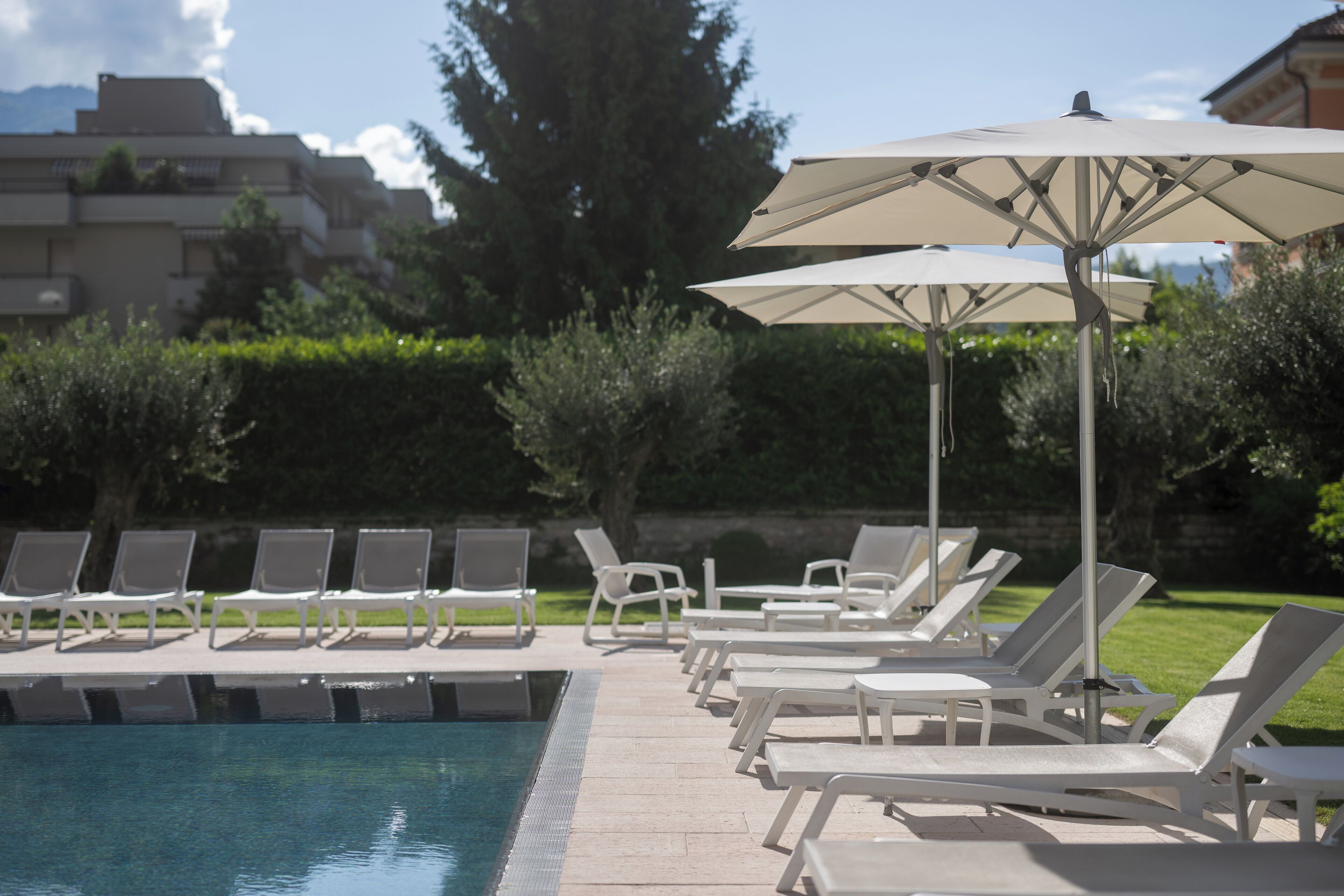 Un espace aménagé au bord de la piscine, avec des chaises longues et des parasols.