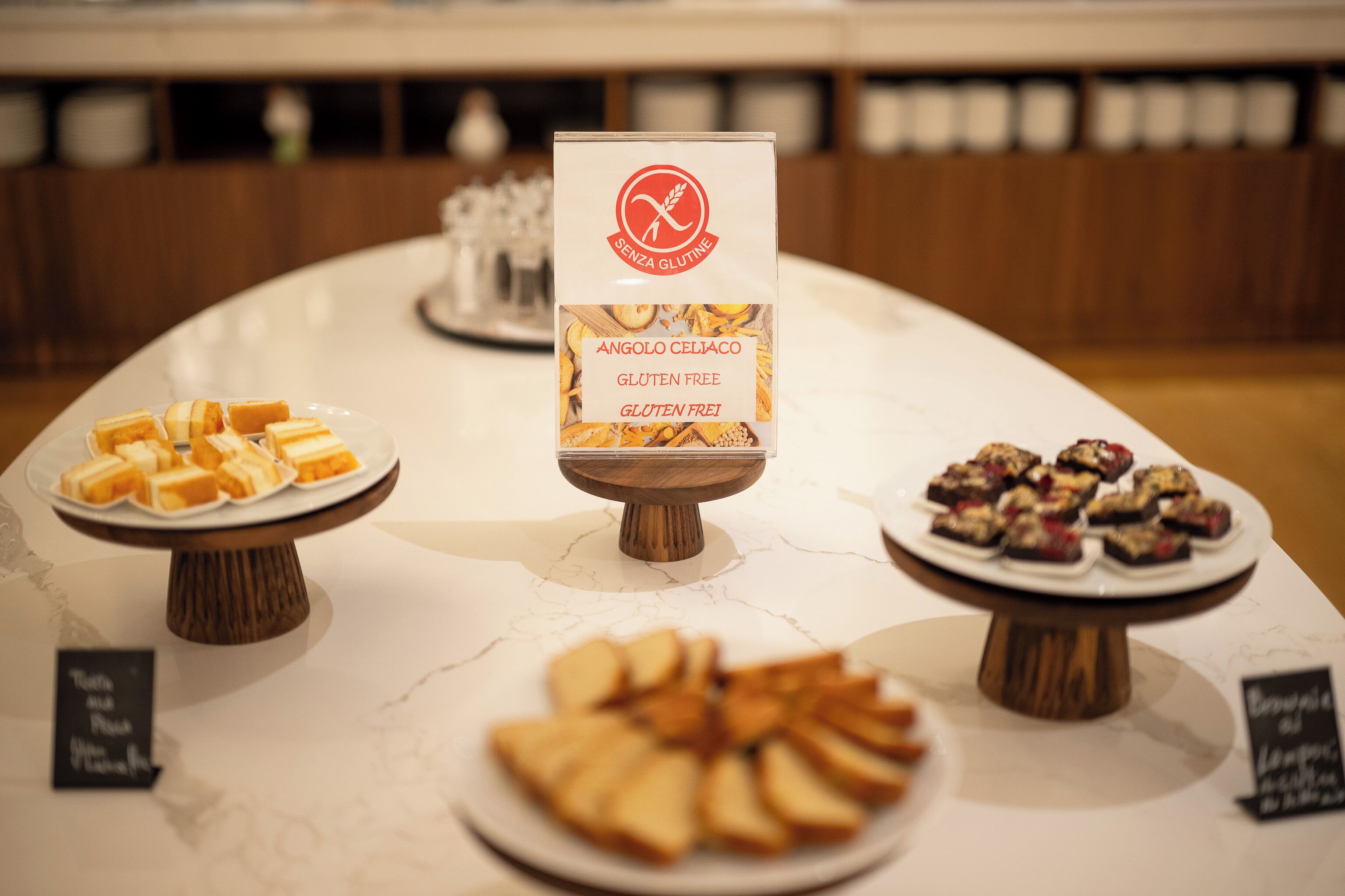 A buffet table with various gluten-free desserts.