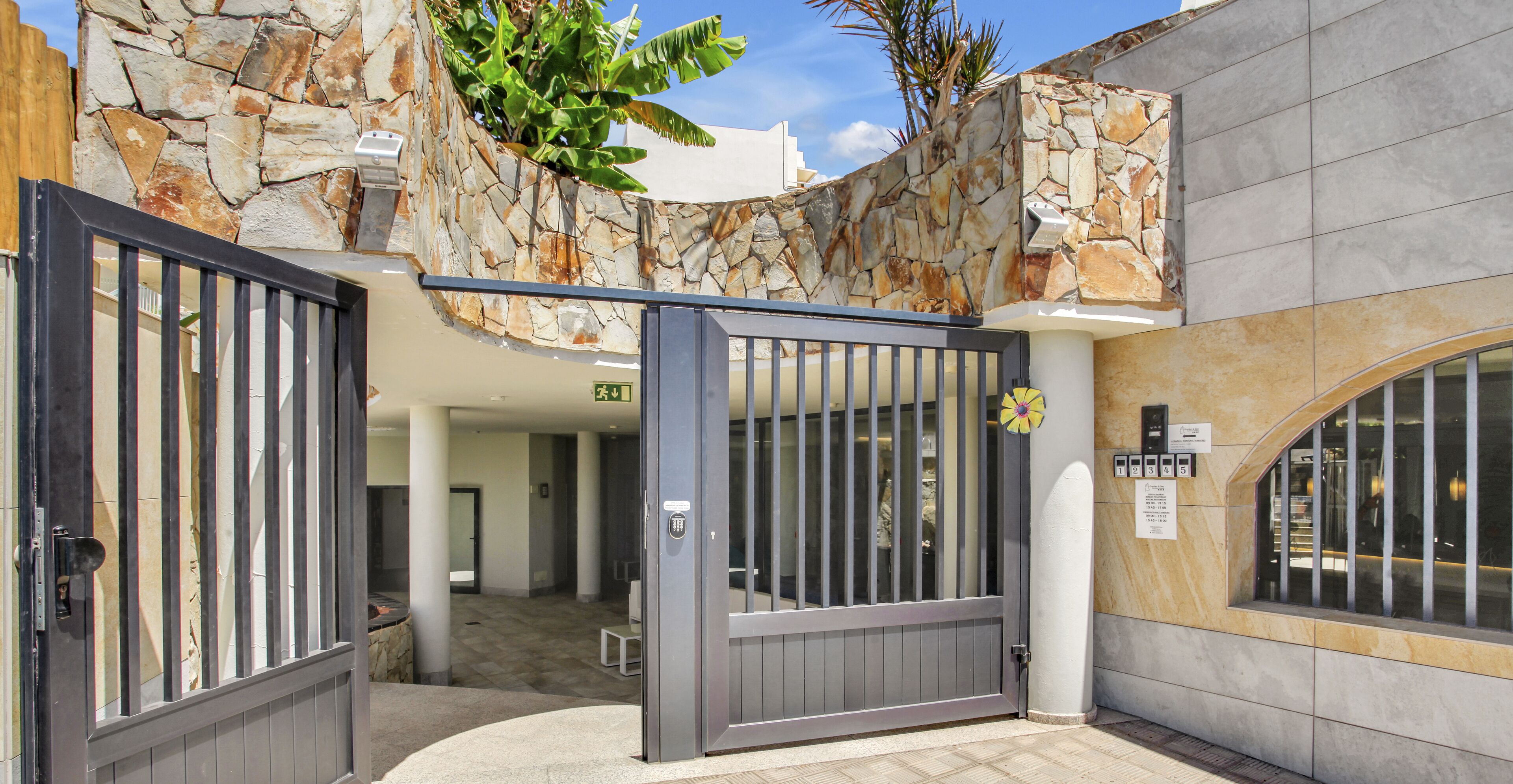 A gated entrance with stone walls and a modern design.