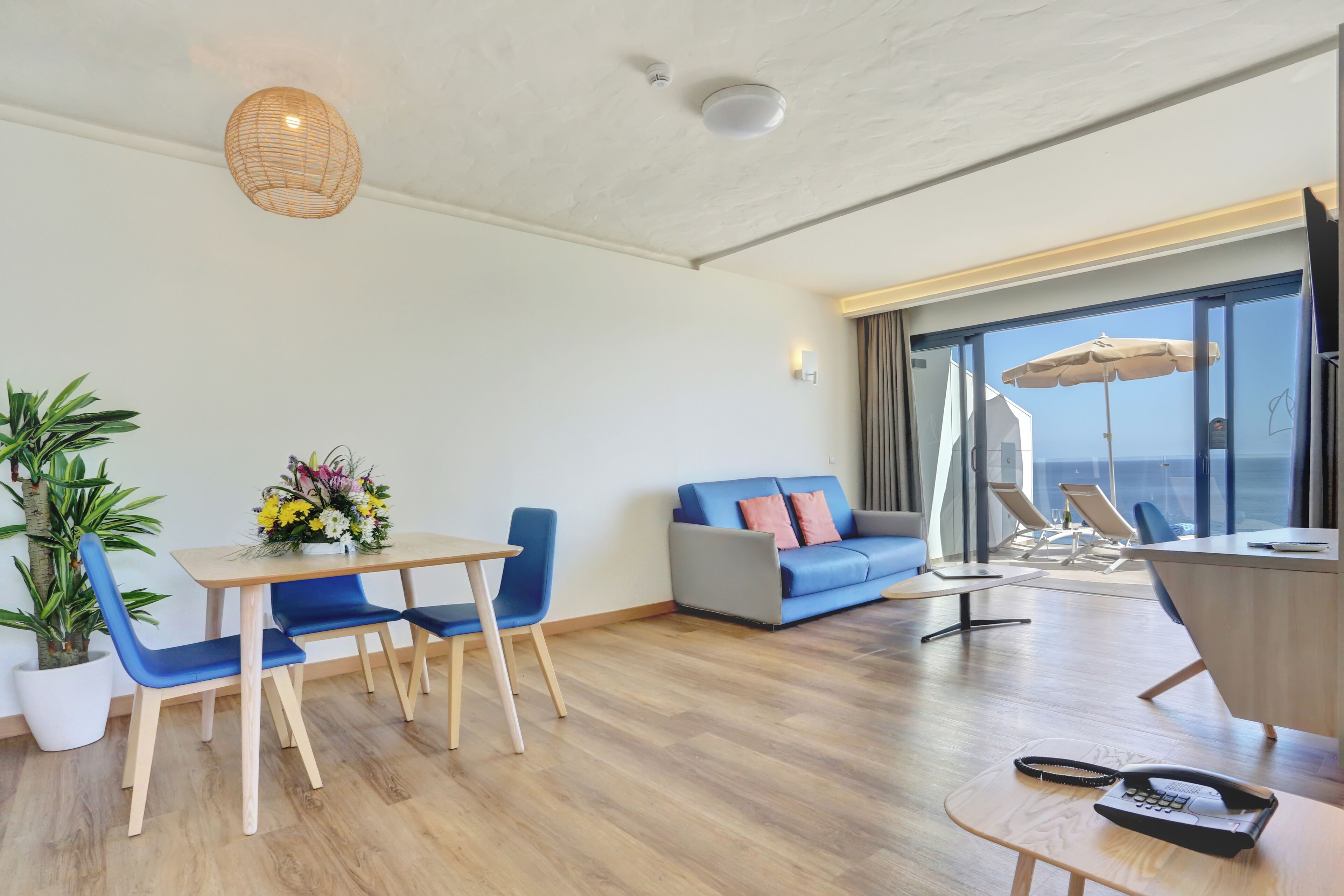 En moderne stue med spiseplads, sofa og havudsigt.