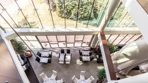 Une terrasse sur le toit, aménagée avec des espaces de détente en plein air, des plantes en pot et offrant une vue sur le paysage environnant.