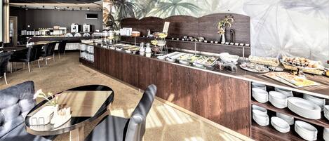 A modern bar area with a buffet setup, leather seating, and a tropical mural backdrop.