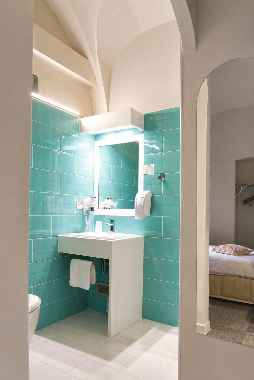 A bathroom with a white sink, a mirror, and a hand dryer.