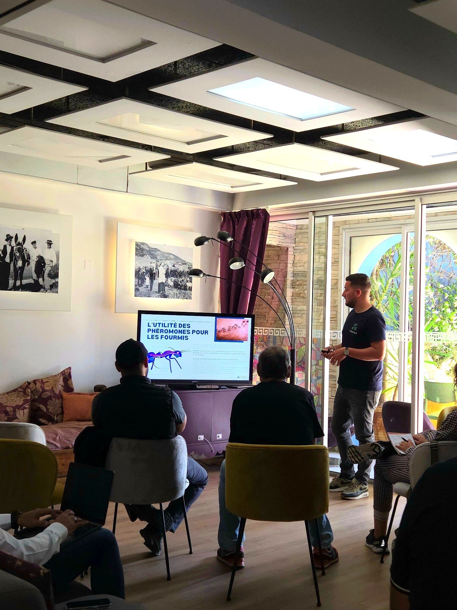A conference room with a presentation screen, a projector, and attendees seated.