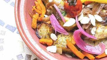 Un plat composé de légumes et de viande rôtis, servi dans un bol en céramique.