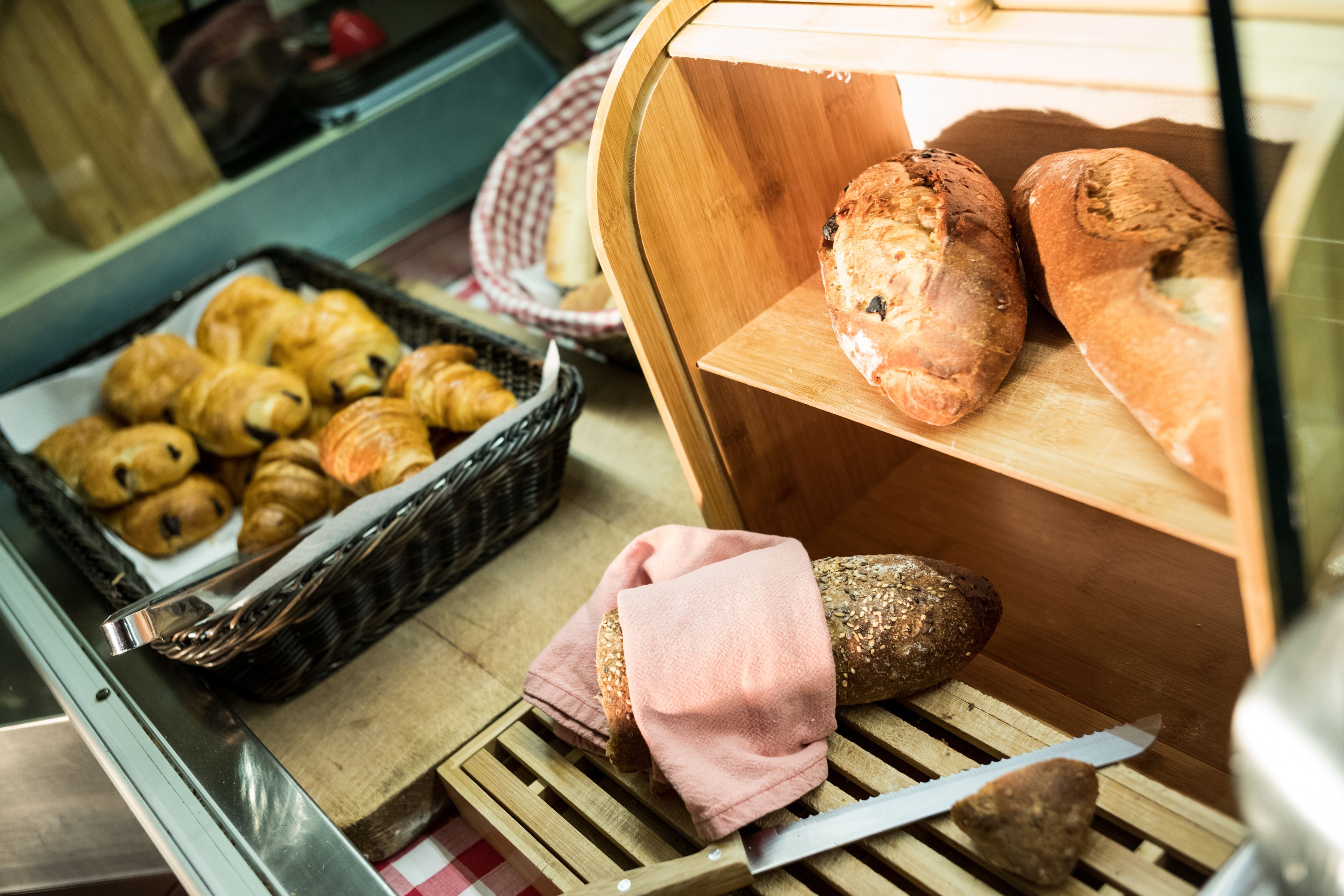 A bakery display with various breads and pastries.