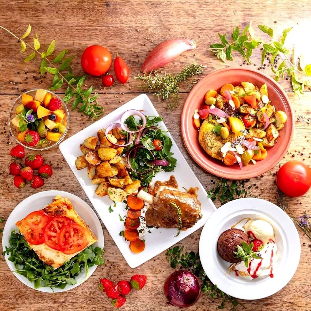 Diverse gerechten, waaronder geroosterde aardappelen, een salade en een toetje.
