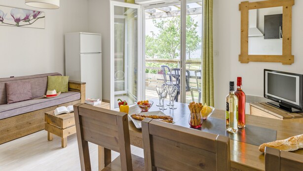 Un salón acogedor con sofá, mesa de comedor de madera y televisor.