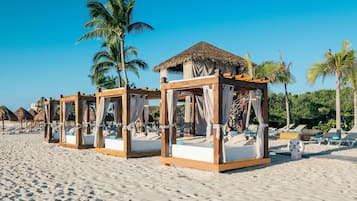 On the beach, white sand, sun loungers, beach umbrellas