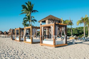 On the beach, white sand, sun loungers, beach umbrellas