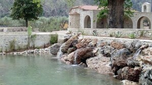 A stone building with arches and a tree in front. - Semantron Traditional Village (Aigialeia)