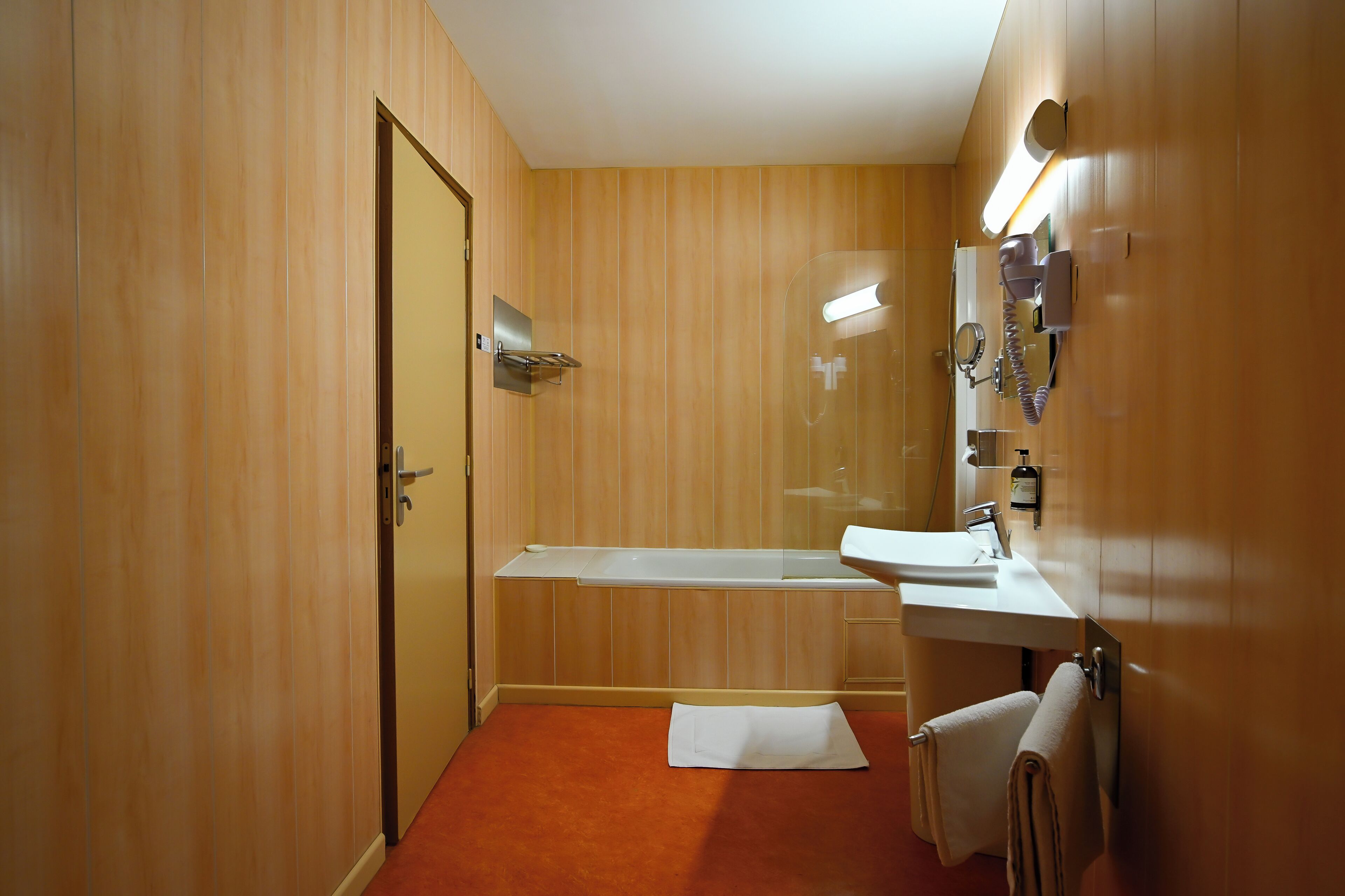 Une salle de bain avec une baignoire, un lavabo et un miroir.