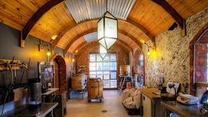 Un intérieur rustique avec des poutres en bois, un mur en briques et une grande fenêtre en arc de cercle.